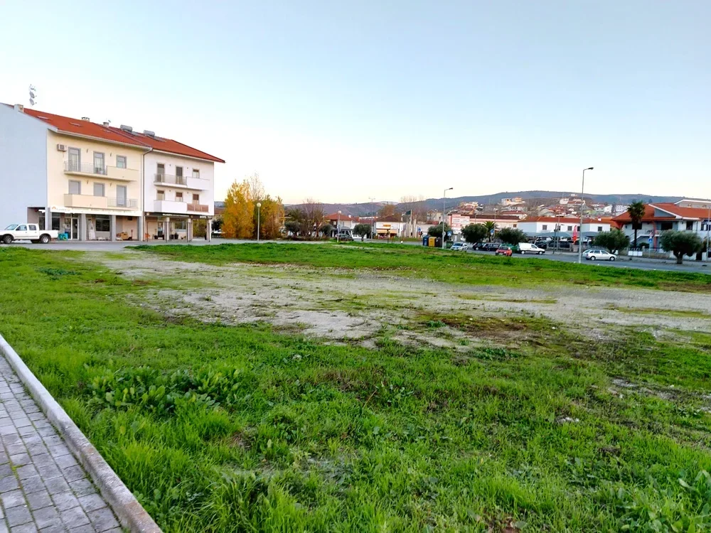 O terreno antes da intervenção: clareira de terra e erva entre os edifícios.