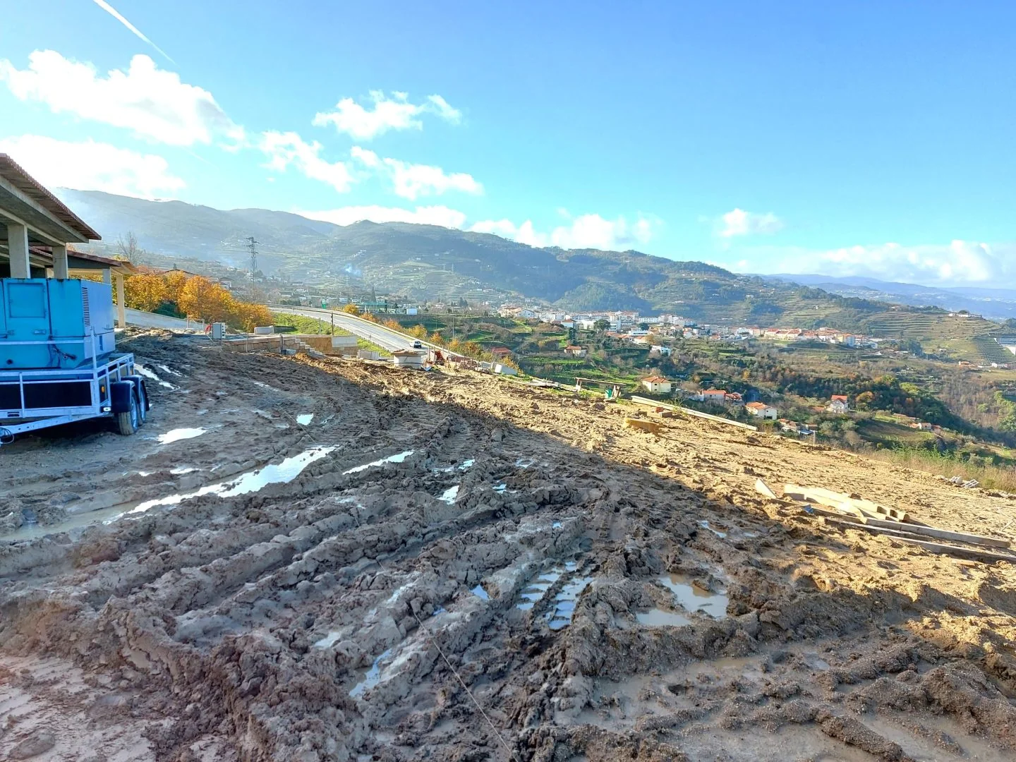 O terreno em obra: plataforma de terra revolvida sobre o vale.